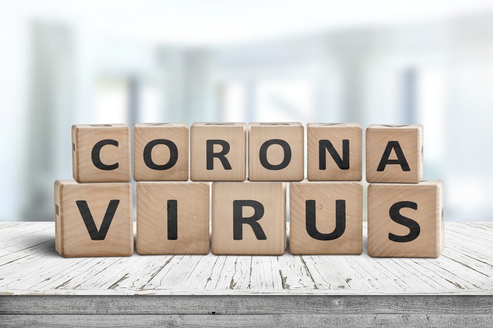 Corona virus alert message on a worn wooden desk